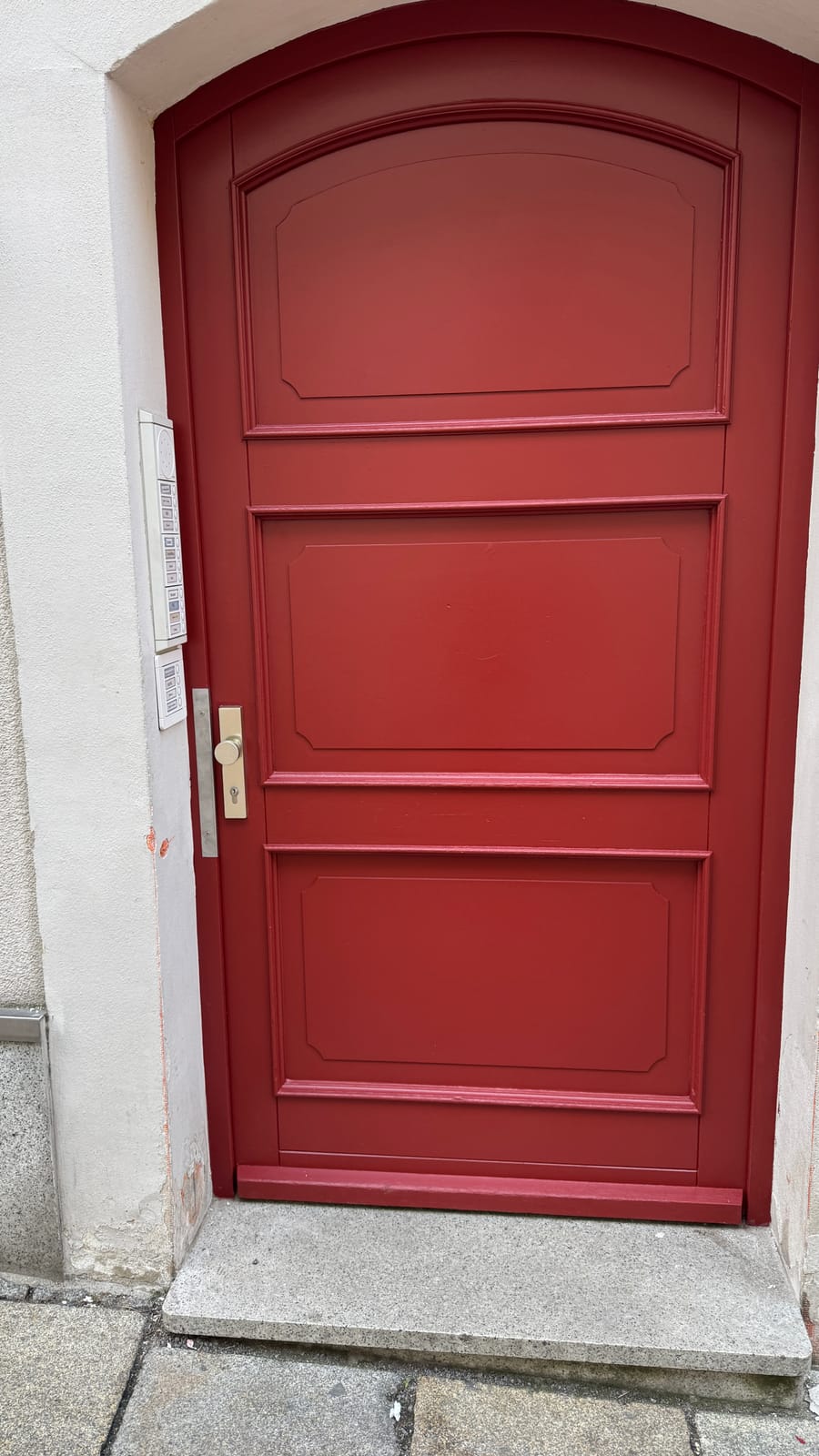 Freshly painted historic arched door in a strong red
